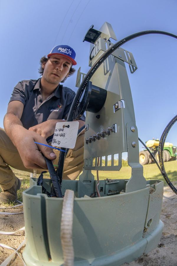 Technician working at a fiber terminal pedestal